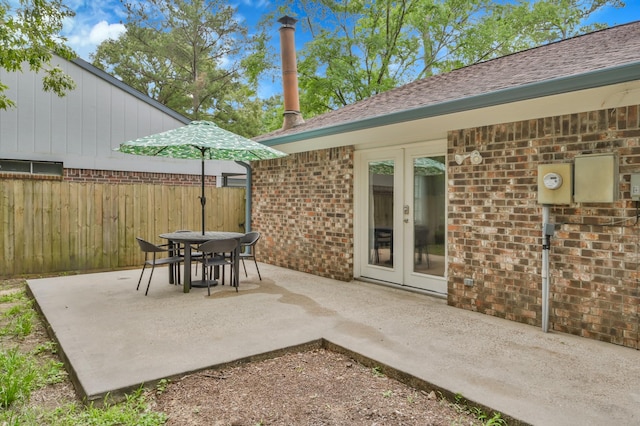view of patio with fence, french doors, and outdoor dining space