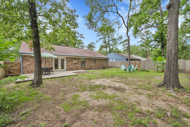 view of yard featuring a patio, french doors, and a fenced backyard