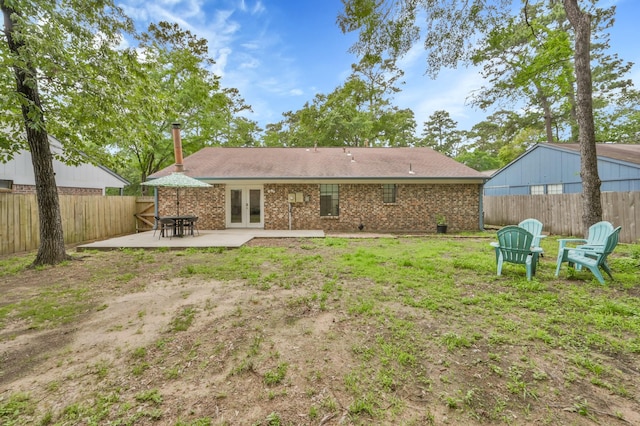 rear view of house featuring a patio, a fenced backyard, french doors, and brick siding