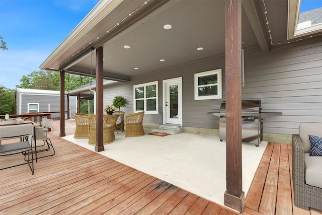 wooden terrace featuring grilling area and outdoor dining space