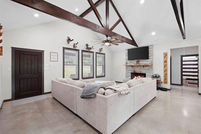 living area featuring beamed ceiling, concrete floors, baseboards, and a fireplace