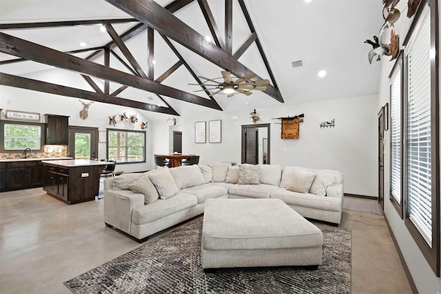 living area featuring visible vents, concrete floors, beam ceiling, and high vaulted ceiling