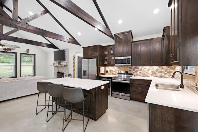 kitchen with backsplash, finished concrete floors, appliances with stainless steel finishes, a sink, and open floor plan
