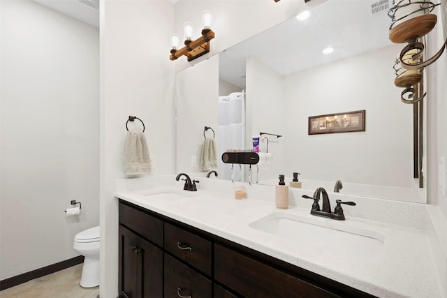 full bath featuring a sink, toilet, and double vanity