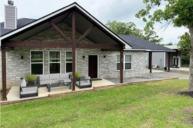 rear view of property with a lawn, outdoor lounge area, a chimney, and brick siding
