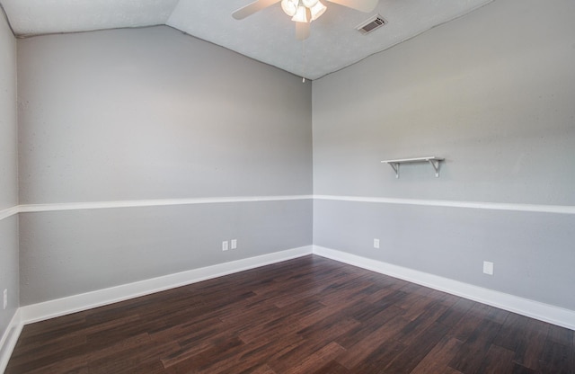 empty room with a ceiling fan, baseboards, vaulted ceiling, dark wood-type flooring, and visible vents