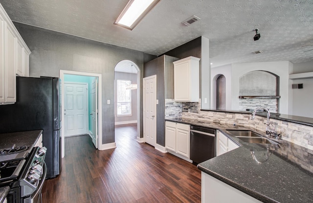 kitchen with a sink, dishwasher, arched walkways, baseboards, and decorative backsplash