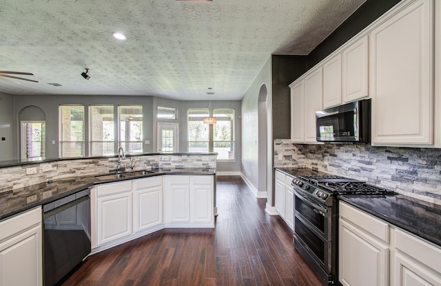 kitchen with double oven range, tasteful backsplash, dishwasher, a sink, and dark wood-style floors