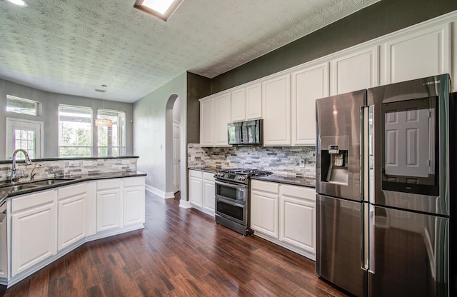 kitchen with a sink, tasteful backsplash, stainless steel appliances, and dark wood-type flooring