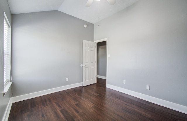 spare room featuring baseboards, ceiling fan, lofted ceiling, and dark wood-style floors