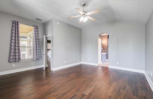 unfurnished living room with arched walkways, a ceiling fan, dark wood-style flooring, and visible vents