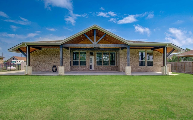back of property featuring a lawn, a patio area, and fence