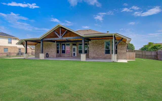 rear view of house featuring a lawn, a fenced backyard, and a patio area