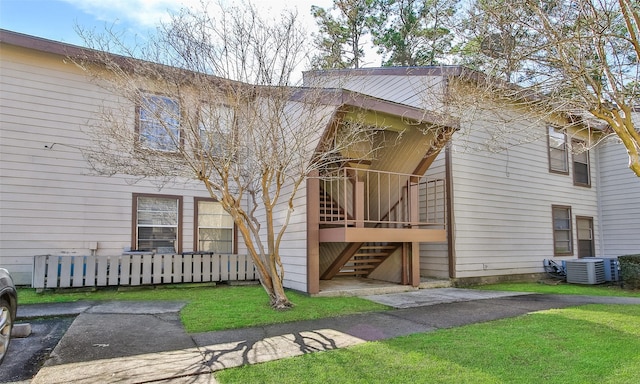 exterior space with central air condition unit, stairway, and fence