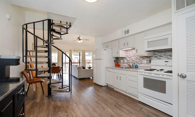 kitchen with visible vents, a sink, white appliances, a textured ceiling, and a ceiling fan