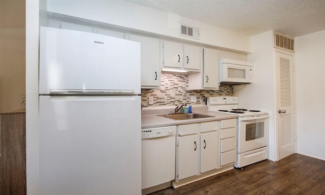 kitchen with visible vents, white appliances, a sink, dark wood finished floors, and backsplash
