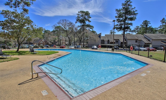 community pool with fence and a residential view