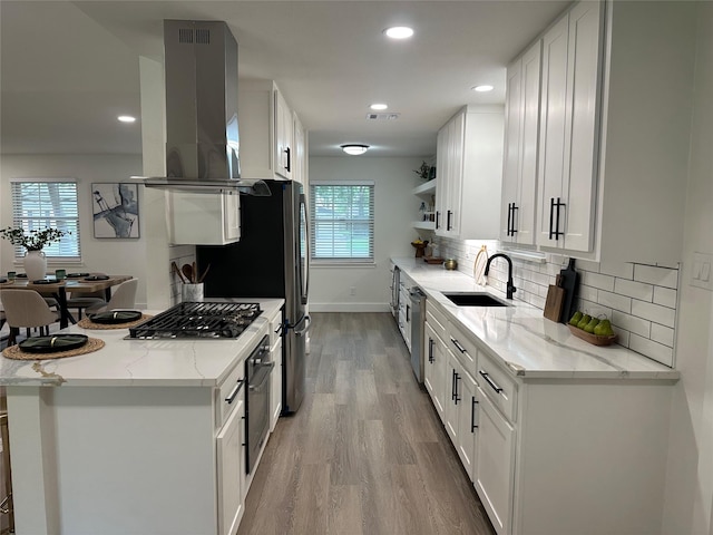 kitchen featuring open shelves, white cabinetry, a sink, light wood-style flooring, and dishwasher