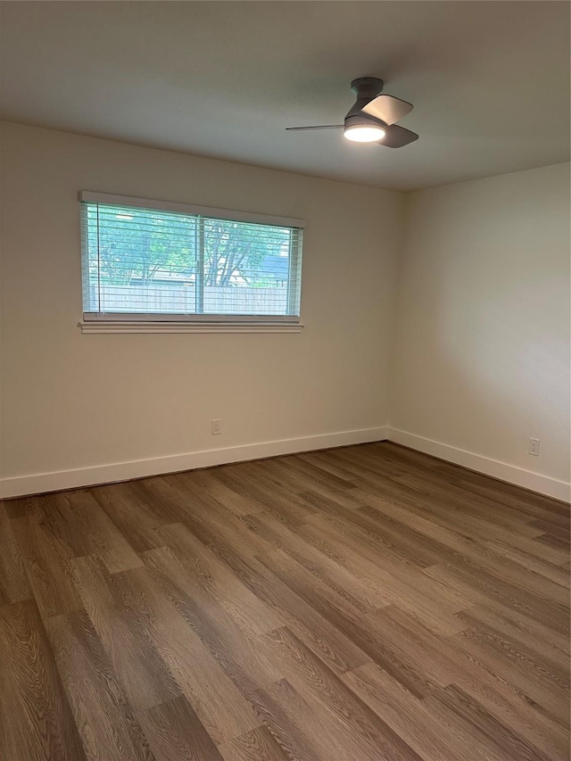 empty room featuring baseboards, a ceiling fan, and wood finished floors
