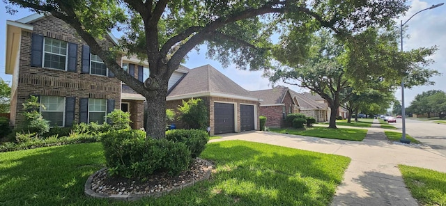 view of front of home featuring concrete driveway, brick siding, an attached garage, and a front lawn