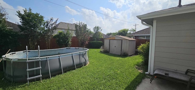 view of yard featuring fence, a storage unit, an outdoor structure, and an outdoor pool