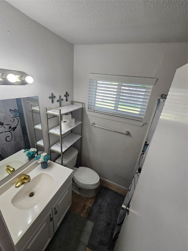 full bathroom featuring vanity, a textured ceiling, wood finished floors, and toilet