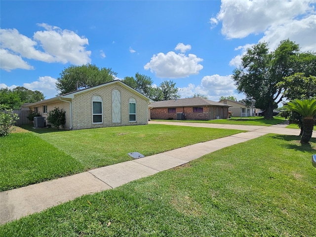 ranch-style house with brick siding, a front lawn, driveway, and cooling unit