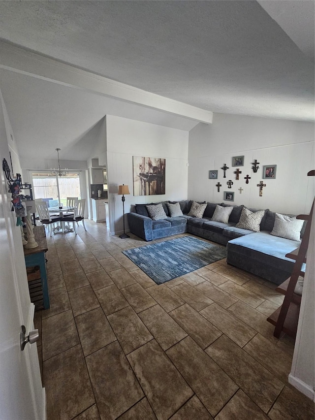 living room featuring vaulted ceiling with beams and an inviting chandelier