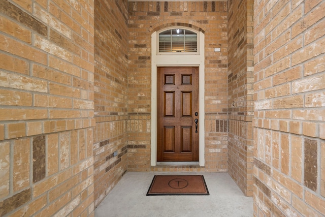 view of exterior entry featuring brick siding