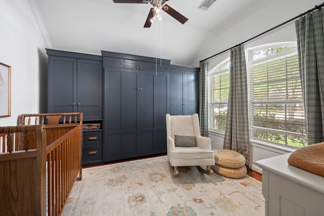 living area featuring a ceiling fan, visible vents, lofted ceiling, ornamental molding, and light wood-style flooring