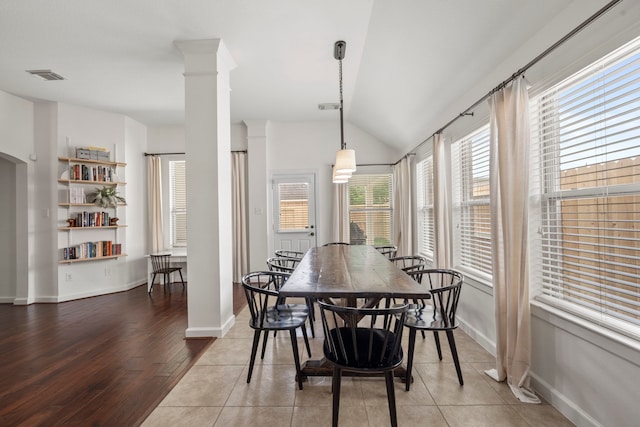dining area with baseboards, visible vents, wood finished floors, and vaulted ceiling
