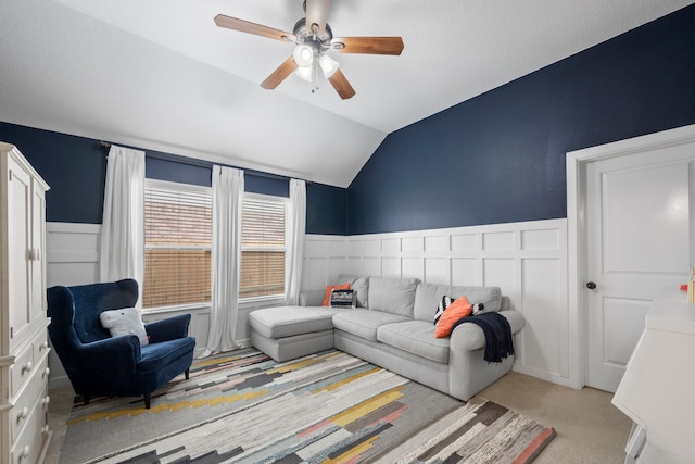 living room with carpet floors, a ceiling fan, wainscoting, and lofted ceiling