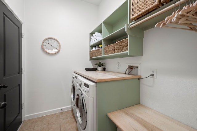 laundry area with light tile patterned floors, baseboards, laundry area, and washer and clothes dryer