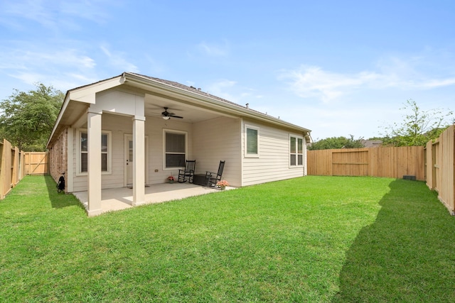 back of house with a fenced backyard, a ceiling fan, a yard, and a patio area