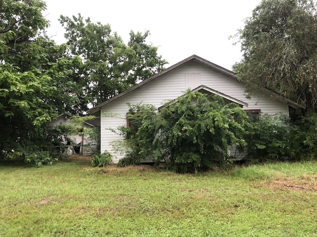 view of side of home with a yard