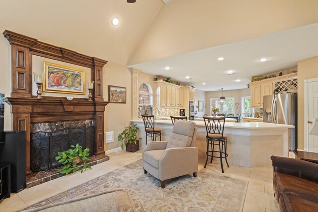 living room with recessed lighting, light tile patterned floors, vaulted ceiling, and a premium fireplace