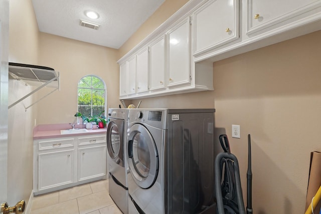 laundry area with washer and dryer, cabinet space, a sink, light tile patterned floors, and visible vents
