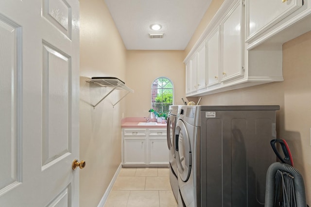 washroom featuring visible vents, cabinet space, light tile patterned floors, baseboards, and separate washer and dryer