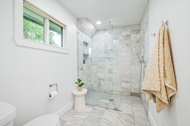 bathroom featuring toilet, baseboards, a tile shower, and marble finish floor
