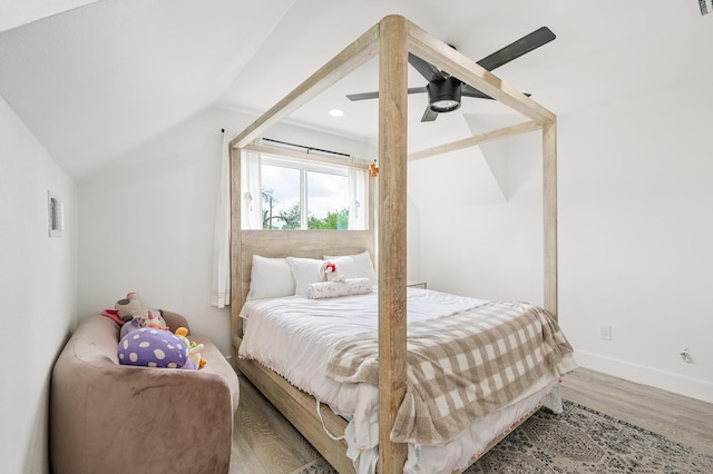 bedroom with baseboards, ceiling fan, wood finished floors, and vaulted ceiling
