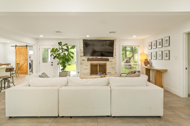 living room featuring visible vents, a barn door, recessed lighting, and a fireplace