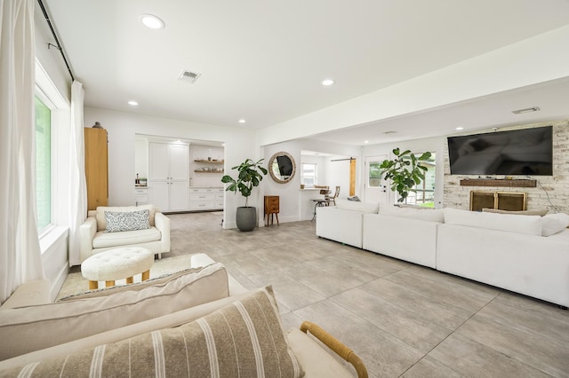 living room featuring light tile patterned flooring, baseboards, visible vents, and recessed lighting