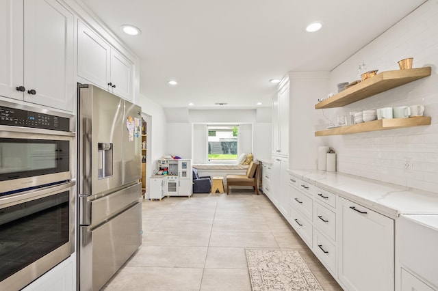 kitchen with open shelves, white cabinetry, appliances with stainless steel finishes, and light tile patterned floors