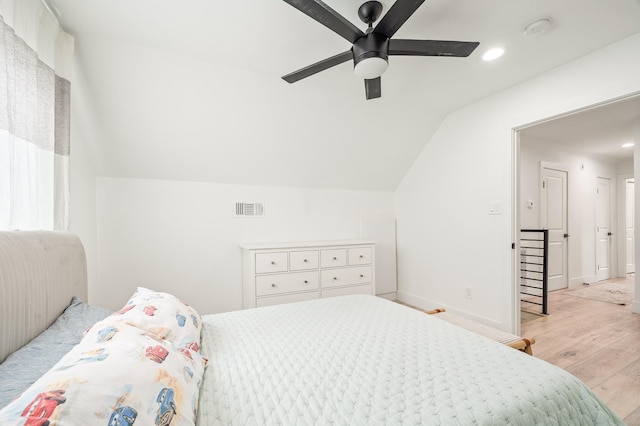 bedroom with visible vents, baseboards, ceiling fan, light wood finished floors, and vaulted ceiling