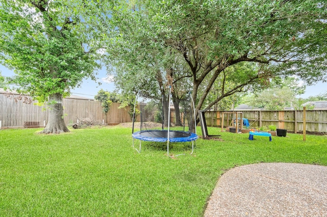 view of yard featuring a fenced backyard and a trampoline
