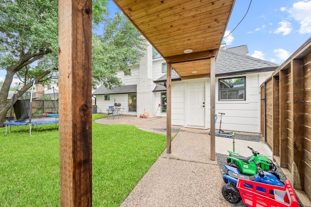view of yard featuring a fenced backyard, a patio, and a trampoline