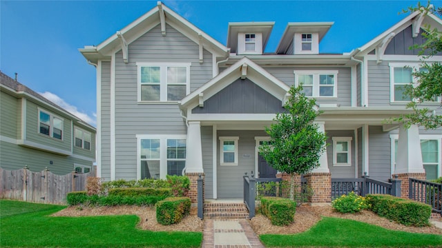 craftsman inspired home featuring a porch, board and batten siding, and fence