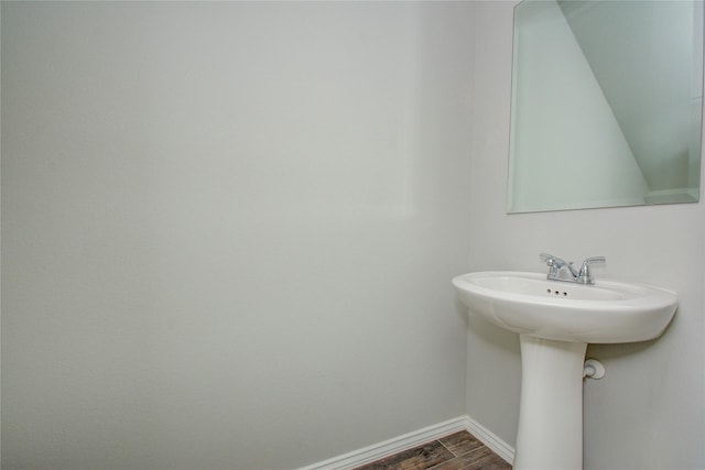 bathroom featuring a sink, baseboards, and wood finished floors