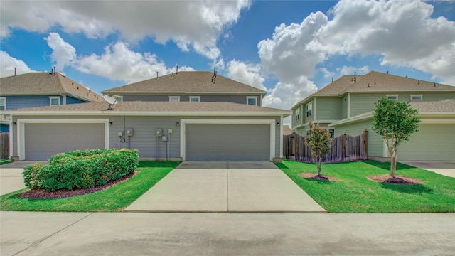 view of front of house with concrete driveway, fence, roof with shingles, and a front lawn
