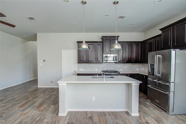 kitchen with light countertops, appliances with stainless steel finishes, tasteful backsplash, and visible vents